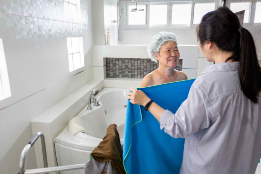 A woman in the bathroom holding a towel