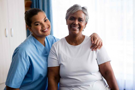 A woman and a nurse smiling for the camera.